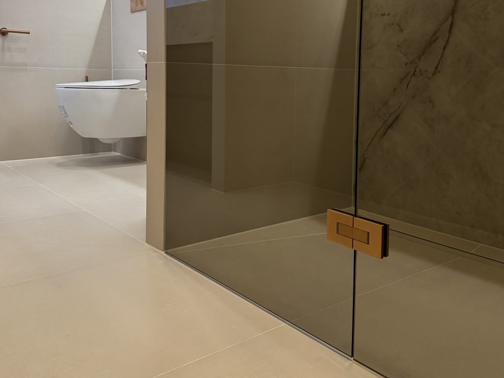 Detail van een mooi gemonteerde luxe douchedeur na een strakke badkamerrenovatie